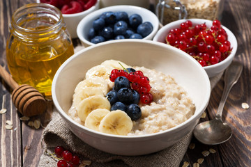 homemade oatmeal with berries on wooden background