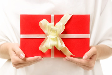 red gift with a bow in the female hands.