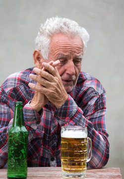 Senior man with beer bottle and mug