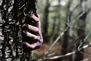 zombie or monster hiding behind a tree
