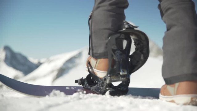 Snowboarder strapping in