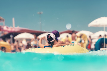 Young people having fun on the water slide with friends and familiy in the aqua fun park glides,...