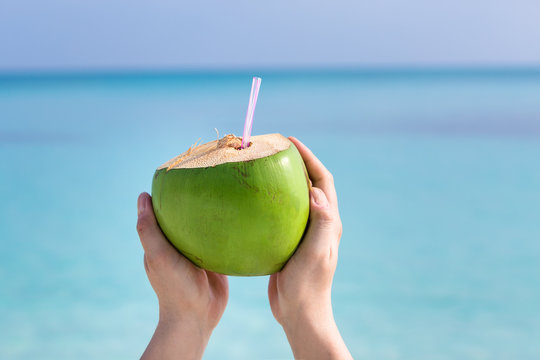 Fresh coconut cocktail in hand
