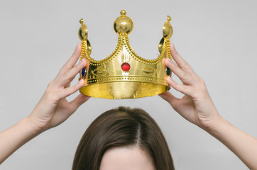 Woman girl holding above a head the golden crown. Leadership, success , queen.