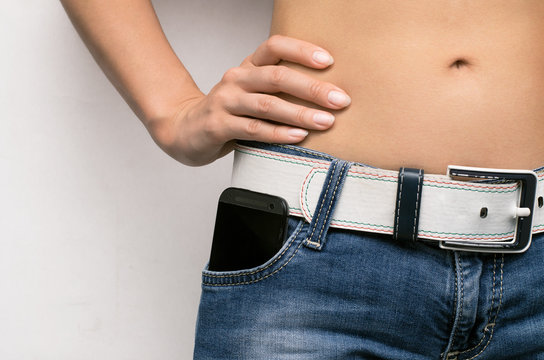 Mobile Phone In Jeans Pocket Of A Girl Person With Hand On The Waist.