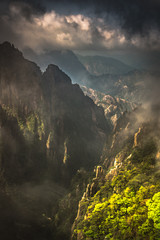 Rugged mountains with fog and mist and sunlight 