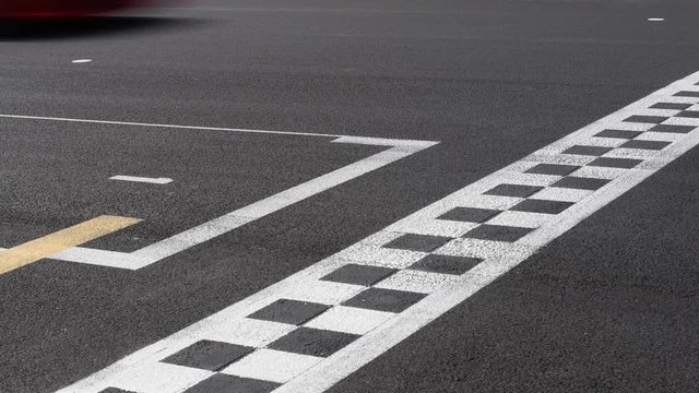 Checkered line and number one sign closeup on racing motorsport track, blurred cars crossing finish line symbol of win, end of the race, first position