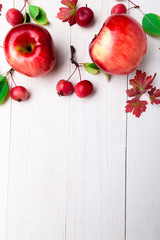 Red apples big and small on white wooden background. Frame. Autumn concept. Top view. Copy space.