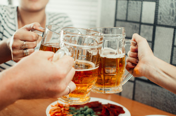 Beautiful beer in a mug holding friends