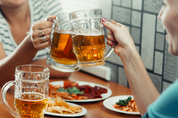 Beautiful beer in a mug holding friends