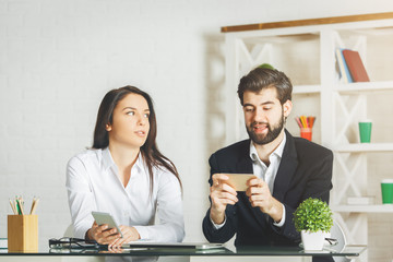 White businessman and woman using smartphone