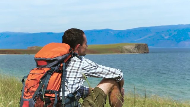 Traveler young Man resting with serene view of lake Baikal. landscape Travel Lifestyle hiking concept summer vacations outdoor