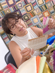 mature brunette woman sewing patchwork