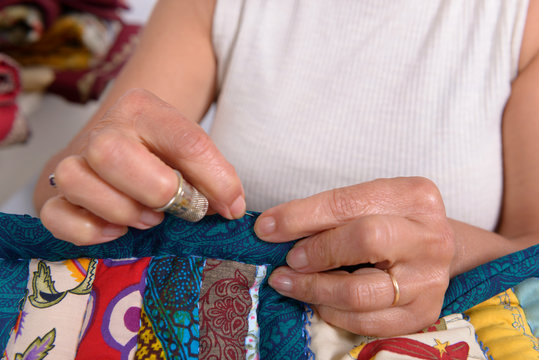 woman sewing for finish a quilt.