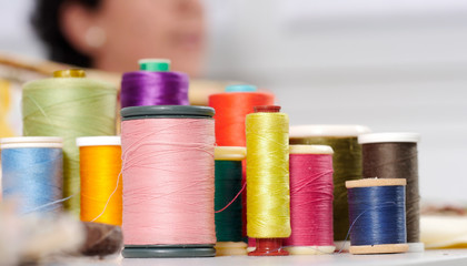 reels of colored threads, seamstress at the bottom