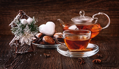 Hot tea in Christmas in a glass transparent Cup with tea, Christmas tree and gingerbread.