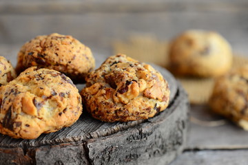 Shortbread biscuits with walnuts on stump and wooden background. Homemade baked sweet pastries photo. Closeup
