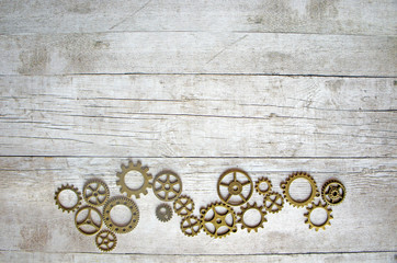 Gears on a wooden gray background, mechanical flat lay with copy space