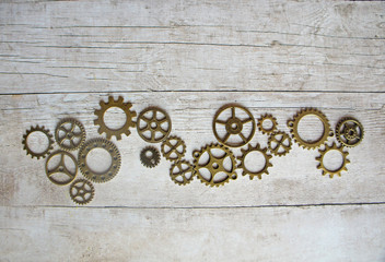 Gears on a gray wooden background, steampunk style flat lay with copy space