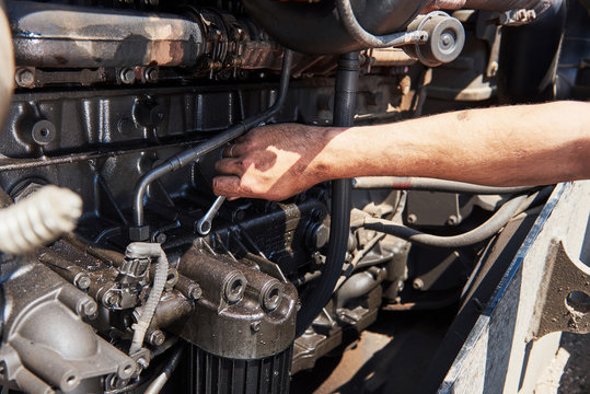 Fototapeta Combine machine service, mechanic repairing motor outdoors