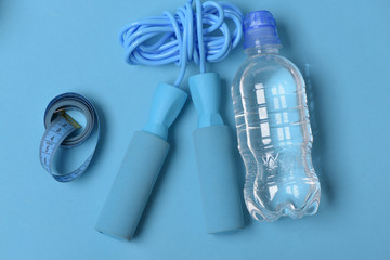 Naklejka premium Skipping rope in cyan color on blue background, top view.