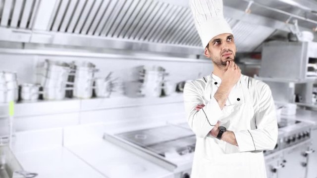 Young male chef thinking idea while wearing uniform and standing in the kitchen room