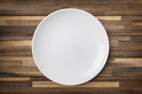 Empty plate on old wooden background. Top view with clipping path