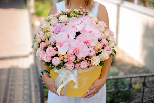 Woman hands with a beautiful pink composition of flowers