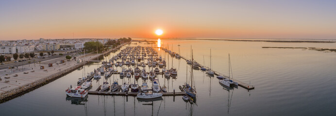 Sunrise aerial seascape view of Olhao salt marsh Inlet, waterfront to Ria Formosa natural park....