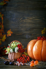 The wooden table decorated wild with flowers by pumpkins and autumn leaves. Autumn background. Happy Thanksgiving Day background.