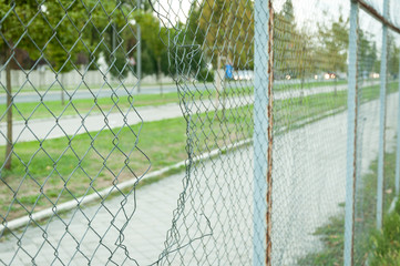 Chain link wire fence with hole in the line with street