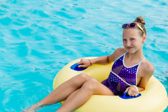 A young girl in the pool on an inflatable lap