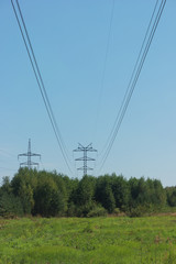 Electrical wires on steel supports. High-voltage power line over forest