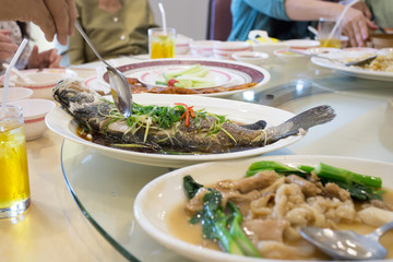 steam snapper fish with vegetable top on white dish, Chinese food