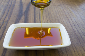 honey dripping on wooden table