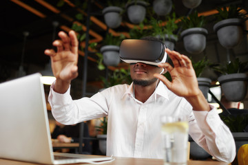 African man in glasses of virtual reality pointing in air.