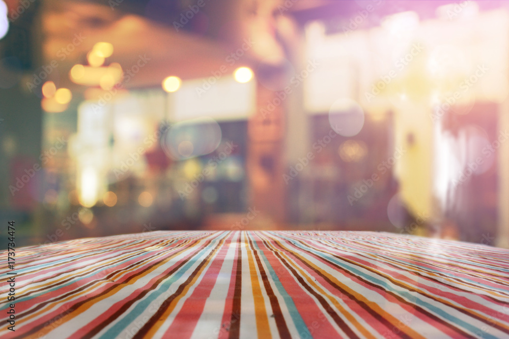 Poster empty table with red polka dot tablecloth over abstract blur bokeh background