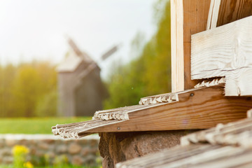 Obraz premium Autumn landscape against the background of a wooden windmill. Wooden windmill in the forest. Autumn landscape in the forest