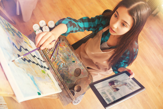 Charming girl painting abstract masterpiece on art canvas
