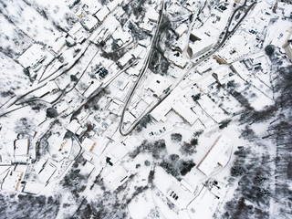 Aerial view of small town with hills in winter.