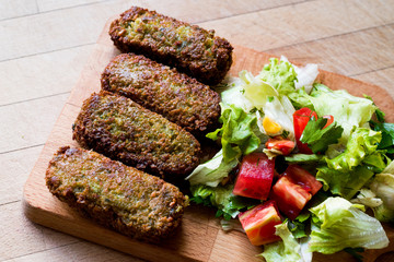 Falafel with Salad on wooden surface.