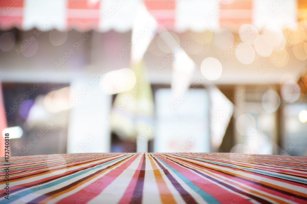 Poster empty table with red polka dot tablecloth over abstract blur bokeh background