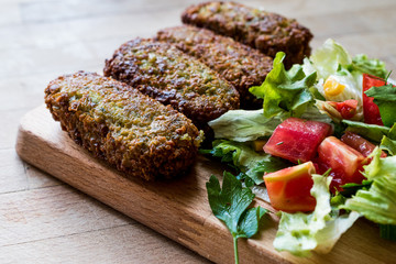 Falafel with Salad on wooden surface.