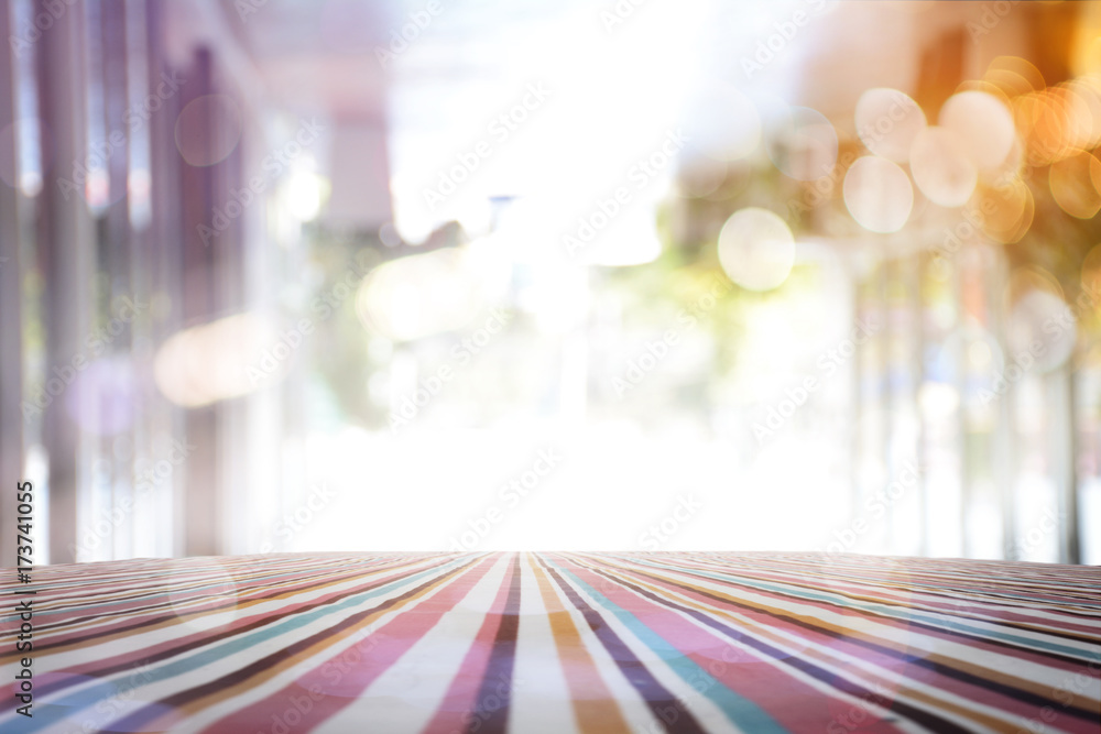 Poster empty table with red polka dot tablecloth over abstract blur bokeh background