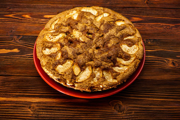 Freshly baked apple pie on a rustic background of dark wood.