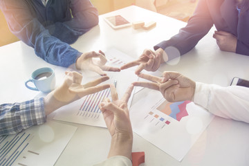Five people engaged in hand with an asterisk