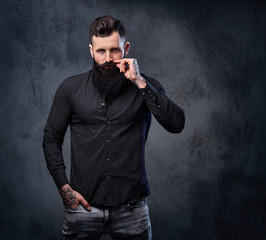 A man in a black shirt with tattoos on his arms.