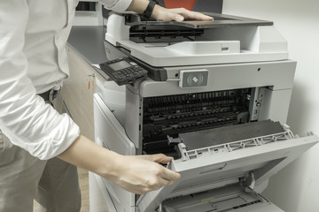 Man Checking paper jam from Photocopier with access control for scanning key card