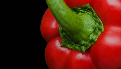 Red bell pepper isolated on black with empty copy space on the side.