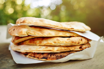 A stack of pita bread on a wooden table .